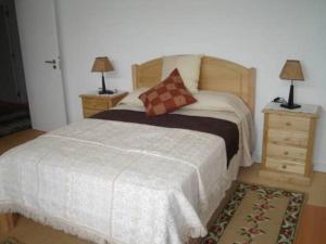 Casa Luís Gonzaga في براغانزا: غرفة نوم مع سرير مع مواقف ليلتين ومصباحين