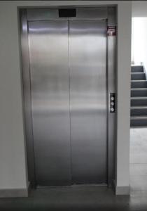 una puerta de ascensor de metal en un edificio con escaleras en Conjunto Payllahue, en Pucón