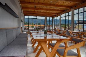 a restaurant with wooden tables and chairs and windows at La Tozi Hotel in San Cristóbal de Las Casas