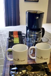 two coffee cups sitting on a table with a coffee maker at Saint Croix at Tagaytay Prime Residences in Tagaytay