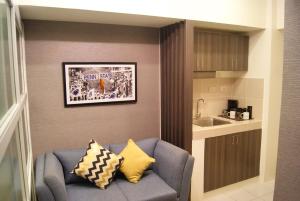 a living room with a blue couch and a kitchen at Saint Croix at Tagaytay Prime Residences in Tagaytay