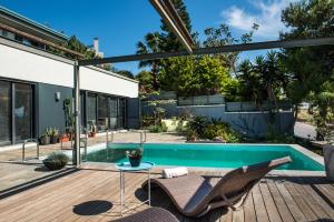 um pátio com uma piscina, 2 cadeiras e uma mesa em Artistic Pool Private Villa em Chania Town