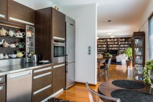 une cuisine avec des placards en bois et une salle à manger dans l'établissement Artistic Pool Private Villa, à La Canée