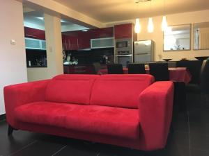 プライア・デ・ミラにあるPraia de Miraのリビングルーム(赤いソファ、キッチン付)