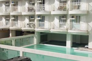 a building with white balconies and a swimming pool at Saint Croix at Tagaytay Prime Residences in Tagaytay