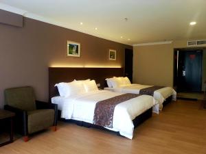 Postel nebo postele na pokoji v ubytování Hotel Anika Kluang