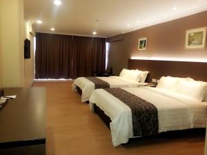 Postel nebo postele na pokoji v ubytování Hotel Anika Kluang