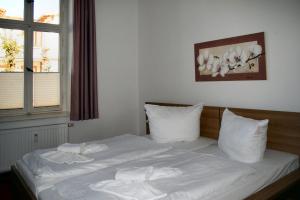 a bedroom with a bed with white sheets and pillows at Ferienwohnung Villa Dora, Seebad Ahlbeck in Ahlbeck