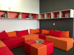a living room with a red and orange couch at YHA Nelson in Nelson