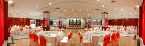 a large banquet hall with white tables and red chairs at Istana Nelayan Hotel in Tangerang