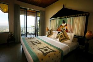 a bedroom with a large bed with a large window at Randholee Resort & Spa in Kandy