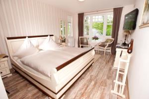 um quarto com uma grande cama branca e uma secretária em Hotel Bess em Albersdorf