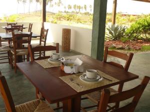 a wooden table with cups and saucers on it at Pé na Areia in Conde