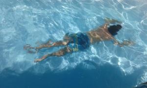 un hombre tirado en el agua en una piscina en Recanto dos Bambus Pousada en Florianópolis