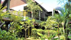 um edifício com um monte de plantas na frente dele em Villa Molek em Pantai Cenang