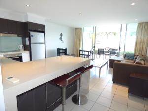 a kitchen and living room with a counter and a couch at Marina View Apartment in Airlie Beach