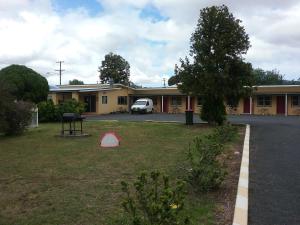 un edificio con un coche aparcado en el patio en Murrurundi Motel, en Murrurundi