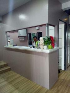 a woman is sitting at a counter in a room at Sunset Villa Inn in Pantai Cenang