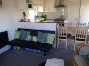 sala de estar con sofá y cocina en Marshlands Lakeside Nature Retreat, en Barton-upon-Humber