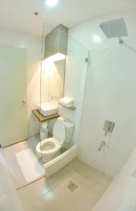 uma casa de banho com um WC e uma cabina de duche em vidro. em Felix Residences em Cebu