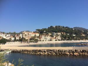 a beach with a bunch of buildings on a hill at B&b note di mare in Imperia