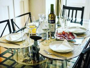 a glass table with plates and wine glasses on it at Best apartment in Baixa-Chiado in Lisbon