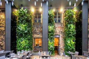 里加的住宿－裡加老城普爾曼酒店，餐厅设有绿色墙壁,配有桌椅