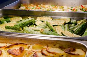 two metal trays filled with vegetables and a pizza at Paradise Bay Resort in Mellieħa