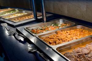 a buffet with several trays of food on a table at Paradise Bay Resort in Mellieħa