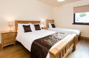 a bedroom with two beds and a window at Lodge 9 Glengoulandie Lodges in Aberfeldy