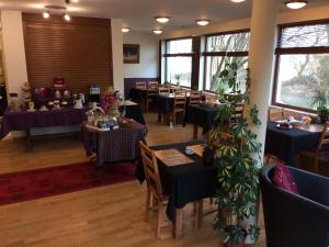 a restaurant with blue tables and chairs and windows at Hôtel Le Chantoiseau in Chaumont-sur-Aire