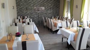 a dining room with white tables and chairs at Steakhaus Galgenbach in Werne an der Lippe