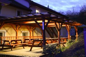 a wooden pavilion with picnic tables in front of a house at Pension Patanka in Prague
