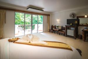 a bedroom with a large bed with a large window at Aonang Sunset Hotel - SHA Extra Plus in Ao Nang Beach