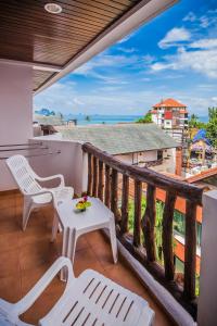 a balcony with white chairs and a table and a view at Aonang Sunset Hotel - SHA Extra Plus in Ao Nang Beach