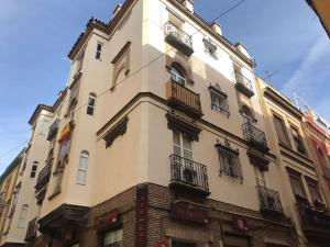 Un edificio alto con balcones a los lados. en CSE San Miguel, en Sevilla