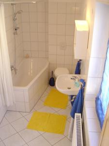 a bathroom with a tub and a sink and a toilet at Ferienwohnung Mayer in Rangsdorf