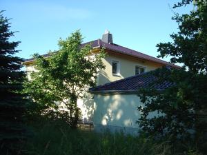 ein weißes Haus mit Bäumen davor in der Unterkunft Ferienwohnung Mayer in Rangsdorf