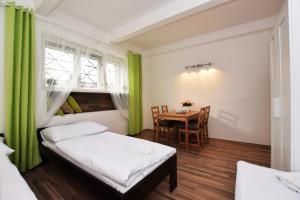 プラハにあるCísařka Apartmentのベッド1台、テーブル(緑のカーテン付)