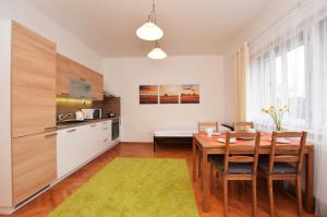 a kitchen and dining room with a wooden table and chairs at Císařka Apartments in Prague