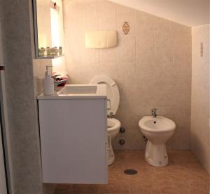 ein Badezimmer mit einem weißen WC und einem Waschbecken in der Unterkunft Emotions in Fiumicino