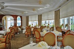 a dining room with tables and chairs and windows at Parkhotel Idar-Oberstein in Idar-Oberstein
