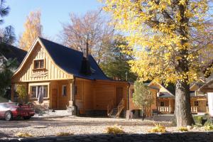 a log cabin with a car parked in front of it at Góralska Osada Karpacz - Apartametny in Karpacz