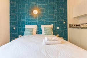 ein Schlafzimmer mit einem weißen Bett und einer blauen Wand in der Unterkunft Apartments WS St Germain - Quartier Latin in Paris