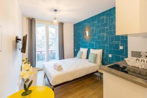 パリにあるApartments WS St Germain - Quartier Latinの青い壁のベッド1台が備わる小さな客室です。