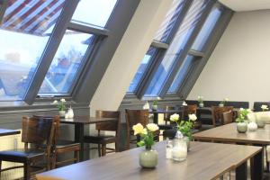 a restaurant with tables and chairs and windows at Hotel Arena Inn - Berlin Mitte in Berlin