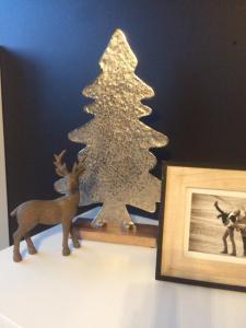 a wooden figurine of a christmas tree next to a picture at Maison Louise in Middelkerke