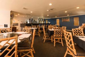 a restaurant with tables and chairs in a room at Sanno Marracoonda Perth Airport Hotel in Perth