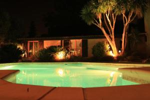 una piscina frente a una casa por la noche en La Bastidasse en La Roquette-sur-Siagne