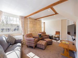 a living room with a couch and chairs and a tv at St Kenelm in Winchcombe